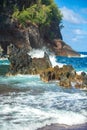 Ocean waves crashing on the rocky island coast. Splashing ocean waves and stones. Red Sand Beach, Maui in in Hawaiian. Royalty Free Stock Photo