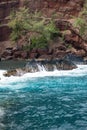 Ocean waves crashing on the rocky island coast. Splashing ocean waves and stones. Red Sand Beach, Maui in in Hawaiian. Royalty Free Stock Photo