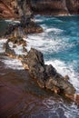 Ocean waves crashing on the rocky island coast. Splashing ocean waves and stones. Red Sand Beach, Maui in in Hawaiian. Royalty Free Stock Photo