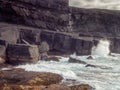 Ocean waves crushing on rough stone coast of rugged Irish coast line with cliffs. Kilkee area, Ireland. Popular travel and tourism Royalty Free Stock Photo