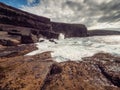 Ocean waves crushing on rough stone coast of rugged Irish coast line with cliffs. Kilkee area, Ireland. Popular travel and tourism Royalty Free Stock Photo