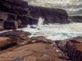 Ocean waves crushing on rough stone coast of rugged Irish coast line with cliffs. Kilkee area, Ireland. Popular travel and tourism Royalty Free Stock Photo