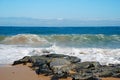 Ocean waves on dark rocks