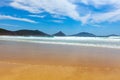 Ocean waves, forested rocky outcrops and blue sky.