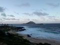 Ocean waves lap on Makapuu beach at dusk