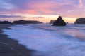 Ocean waves long exposure coming in at Oregon shore with dramatic sea stacks. Royalty Free Stock Photo