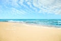 Ocean waves rolling on sandy beach under sky with clouds Royalty Free Stock Photo