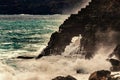 Ocean waves splash through, hole in rocks. Cave formation at shoreline in Tenerife. Aqua foam power scene. Stormy wave splashing