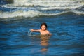 Ocean wawes on the background. Kid swimming in sea with wawes. Little boy playing in outdoor jumping into water on Royalty Free Stock Photo