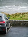 Ocean weaves in focus, Small black car out of focus in foreground. Royalty Free Stock Photo