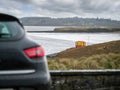 Ocean weaves in focus, Small black car out of focus in foreground. Royalty Free Stock Photo