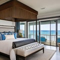 Oceanfront Escape: A coastal-inspired master bedroom overlooking the ocean, with a canopy bed, nautical accents, and a balcony t