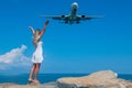 Oceanic Connection: A Girl in a White Dress on Stones Meets a Flying Plane