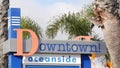 Oceanside nameboard sign and palm trees. Oside is the popular american tourist resort, pacific ocean west coast, San Diego County Royalty Free Stock Photo