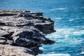 Oceanside rocky cliff top with blue coastal sea in background