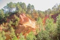 Ochre Trail in Roussillon, Sentier des Ocres, hiking path in a natural colorful area of red and yellow cliffs surrounded by green