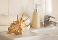 ÃÂ¡ockleshell and Bath white cotton towels, ceramic bottle on Blurred bathroom interior background with sink and faucet Royalty Free Stock Photo