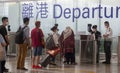 Travelers queue in the departure hall of the Hong Kong International Airport