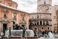 Fuente del Turia fountain and tourists at Valencia Cathedral square with church and bell tower in background