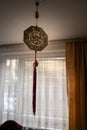 Octagon Bagua Mirror Feng Shui hanging from a roof inside a room against curtains- powerful cure to protect against negative Royalty Free Stock Photo