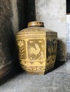Octagon-shaped glazed water jar with rooster pattern.