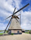 Octagonal drainage windmill with thatched roofing, blue sky and clouds, Netherlands.