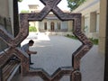 Octagonal frame of wrought iron with behind a sitting man in Uzbekistan.