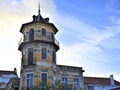 Octagonal tower with four floors, tiled friezes on facades, balconies and wrought iron railings.