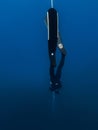 October 03, 2022. Amed, Indonesia. Freediver in wetsuit with fins training dive on deep in blue ocean. Professional freediving
