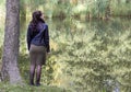 October 15, 2023, Belarus, Minsk. A beautiful confident woman stands on the shore of a lake, autumn weather. Loneliness, thoughts