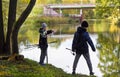 October 15, 2023. Belarus, Minsk.Young fishermen. boys in dark jackets and sneakers stand on the shore with fishing rods. Outdoor Royalty Free Stock Photo