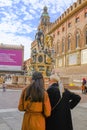 October 2021 Bologna, Italy: Two young women in stylish clothes studing the city map near the Neptune Fountain on the square Piazz Royalty Free Stock Photo