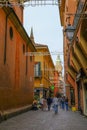 October 2021 Bologna, Italy: Via Clavature street Quadrilatero, tourists walking across the song lights across buildings and sky Royalty Free Stock Photo