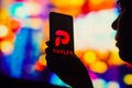 October 17, 2022, Brazil. In this photo illustration, a silhouetted woman holds a smartphone with the Parler logo displayed on the