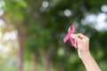 October Breast Cancer Awareness month, adult Woman  hand holding Pink Ribbon with green background for supporting people living Royalty Free Stock Photo