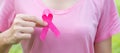 October Breast Cancer Awareness month, adult Woman in pink T- shirt with hand holding Pink Ribbon for supporting people living and