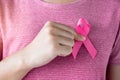 October Breast Cancer Awareness month, Woman in pink T- shirt with hand holding Pink Ribbon for supporting people living and