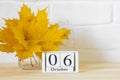 October 6 on the calendar and a bouquet of bright autumn leaves on the table.One of the days of the autumn month.Calendar for Royalty Free Stock Photo