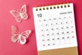 A October 2023 calendar desk for the organizer to plan and reminder with butterfly paer on red background Royalty Free Stock Photo