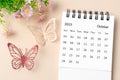 The October 2023 desk calendar for the organizer to plan, reminder and butterfly paer with flower on yellow background