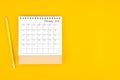 October 2023 desk calendar and wooden pencil on yellow color background. Time planning, day counting and holidays