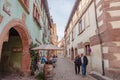 People sightseeing in beautiful French village and enjoy outdoor restaurants.