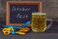 October fest concept. Beer mug with snacks of salt pritzels, bretzel and board with the words