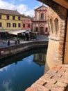 October 2018 Fontanellato, Parma: view from Rocca sanvitale to the city street and restaurant. Water reflections. Medieval brick c