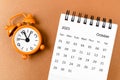 A October 2023 Monthly desk calendar for the organizer to plan 2023 year with alarm clock on yellow background Royalty Free Stock Photo