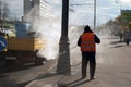 October 2017, Moscow, Russia. A worker in an orange vest like paper and dirt from the roadside pillars