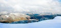 October mountain beech forest edge with first winter snow and last autumn colourful foliage on far mountainside Royalty Free Stock Photo