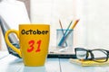 October 31st. Day 31 of month, calendar on hot coffee cup at translator or interpreter workplace background. Autumn time