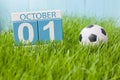 October 1st. Day 1 of month, color calendar on green grass background with a ball. Autumn time. Football and soccer play Royalty Free Stock Photo