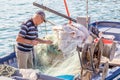 20 October 2014. Syracuse, Italy: Senior fisherman unraveling th